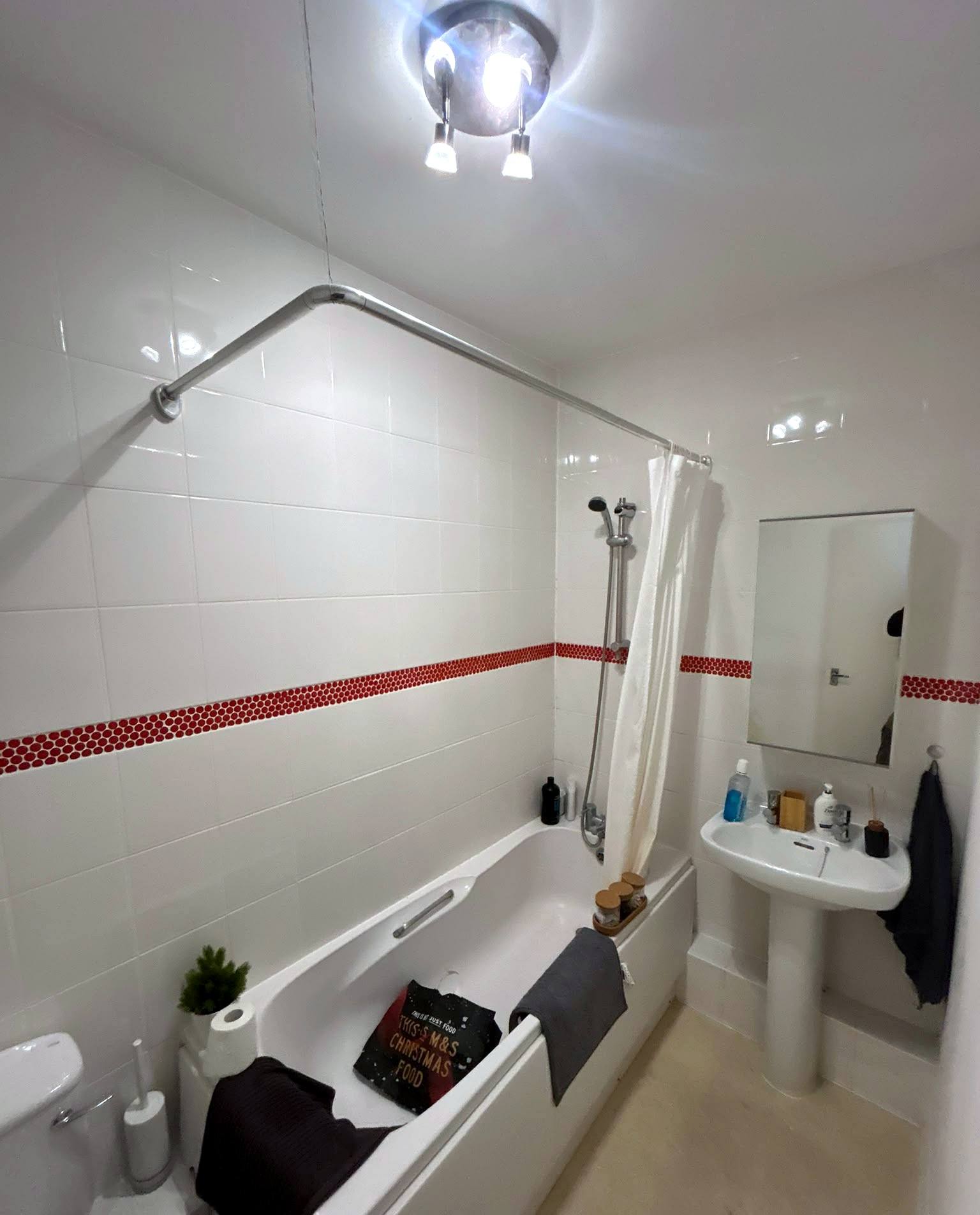 Bathroom with new bath, shower, basin and wall tiling