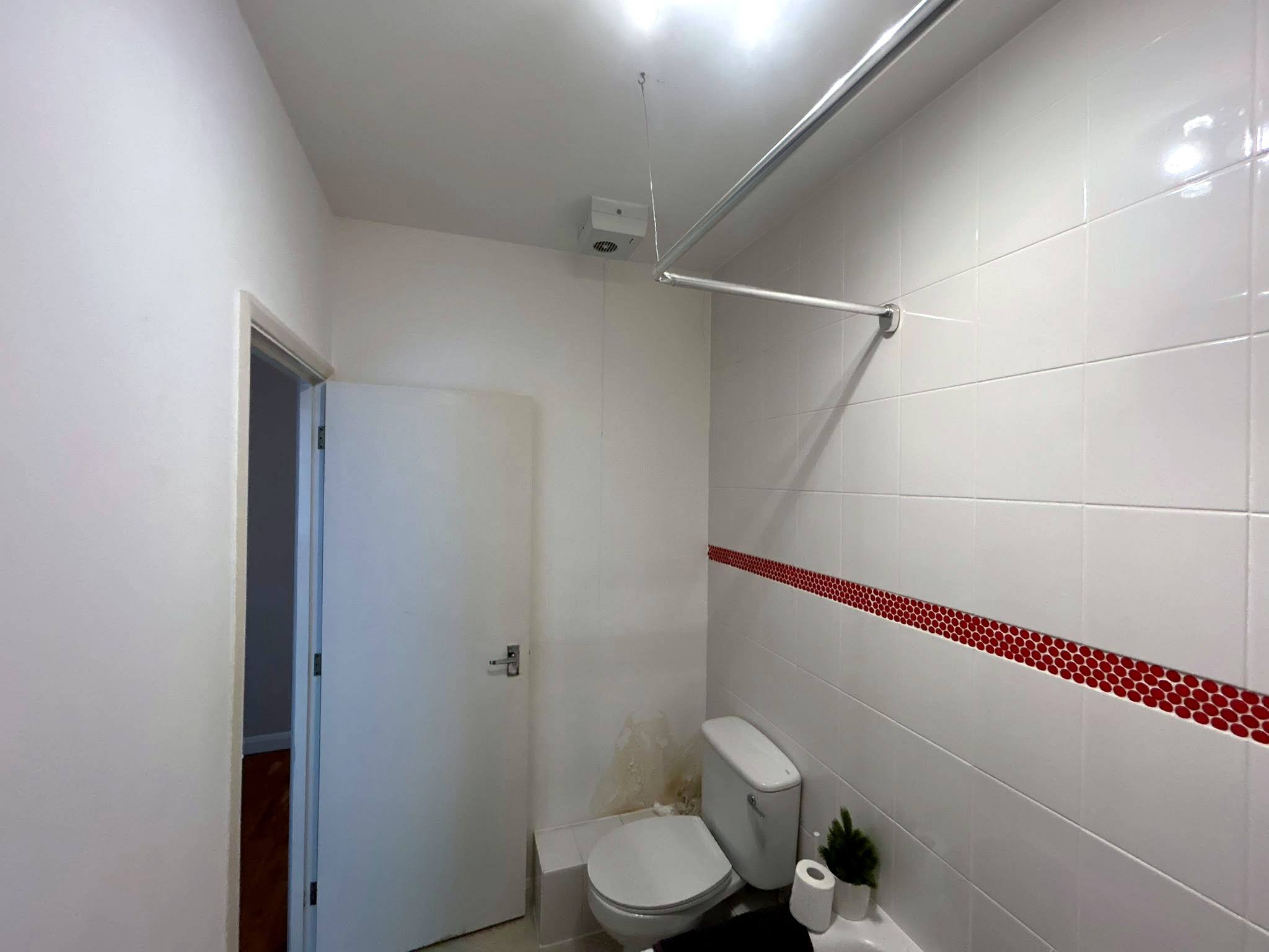 White wall tiling with a red mosaic border
