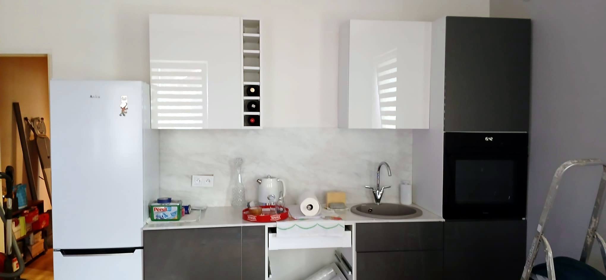 Kitchen in a flat with tall oven housing and integrated fridge space