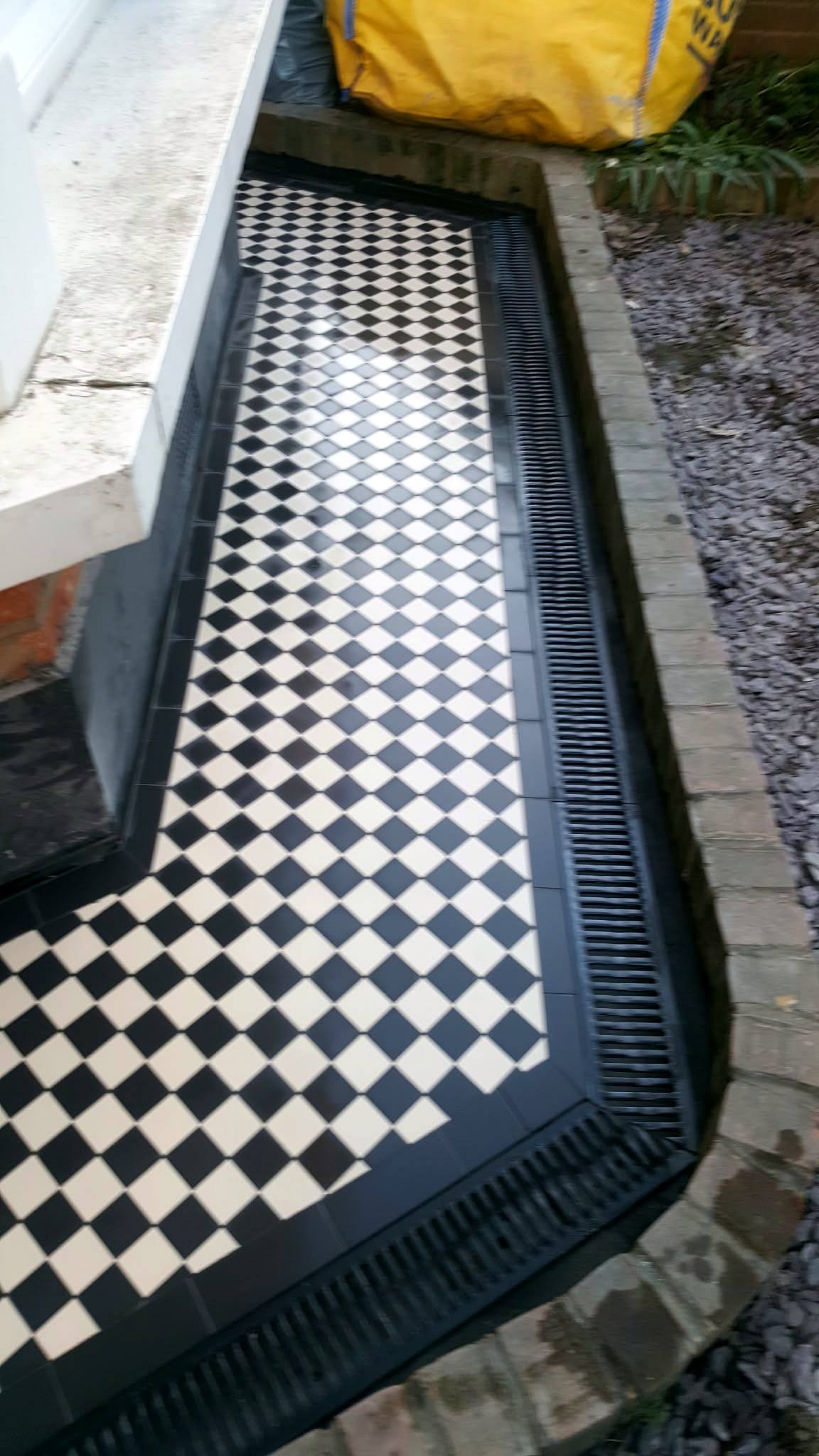 Tiled path following a bay window